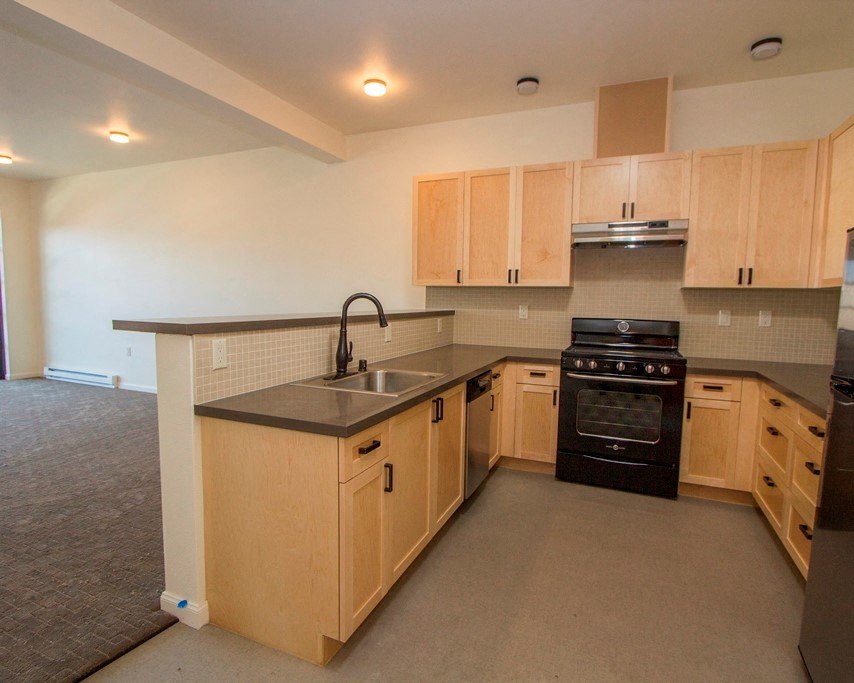an empty kitchen with wooden cabinets and a sink